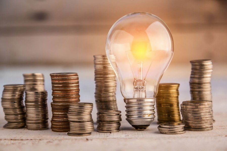 energy efficient light bulb and pile of coins